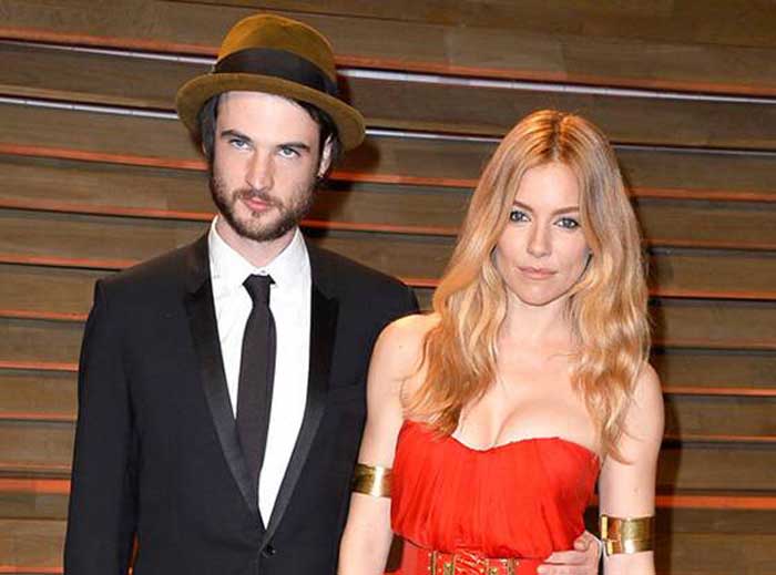  Tom Sturridge, and Sienna Miller posing for a picture.
